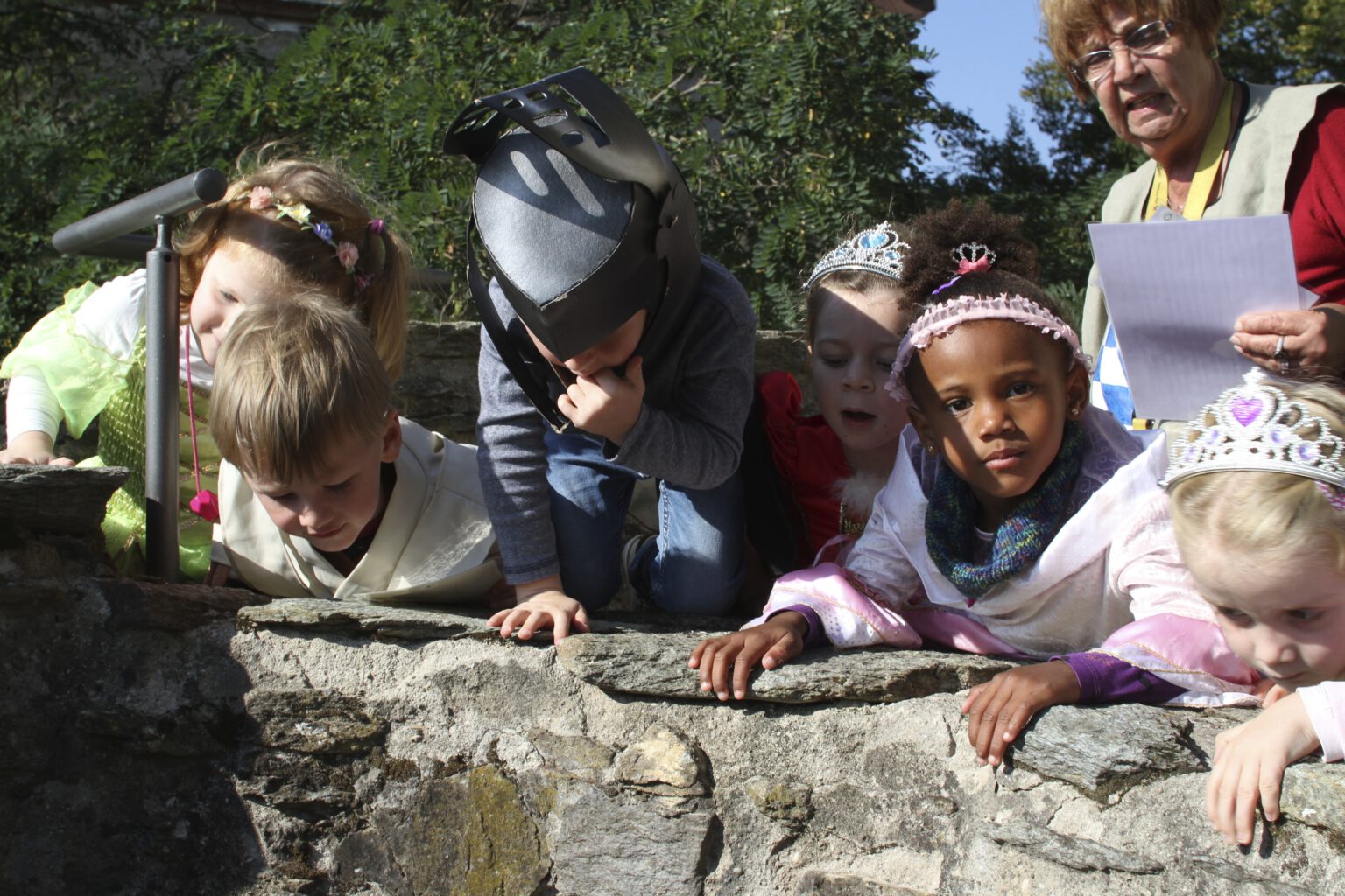 Kinder schauen in eine Zisterne der Burg